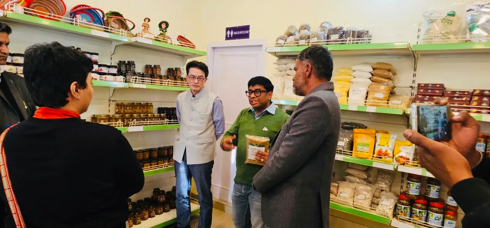 HFN explaining producer products to visitors during the HFN Store inauguration.